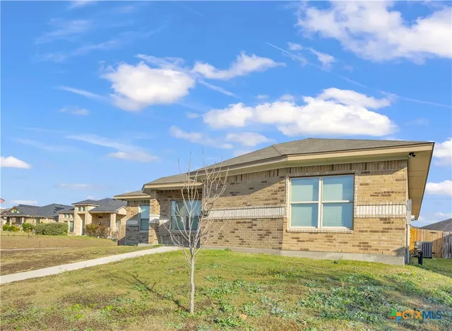 a view of a house with backyard and a garden