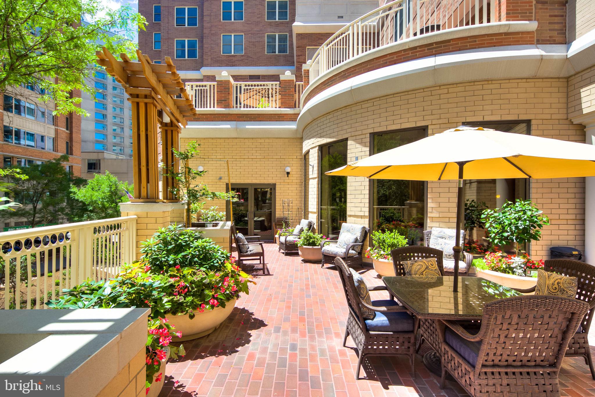 900 North Taylor Street, Unit 507 Arlington, VA 22203 - Photo 22 of 23 a view of a patio with couches table and chairs under an umbrella