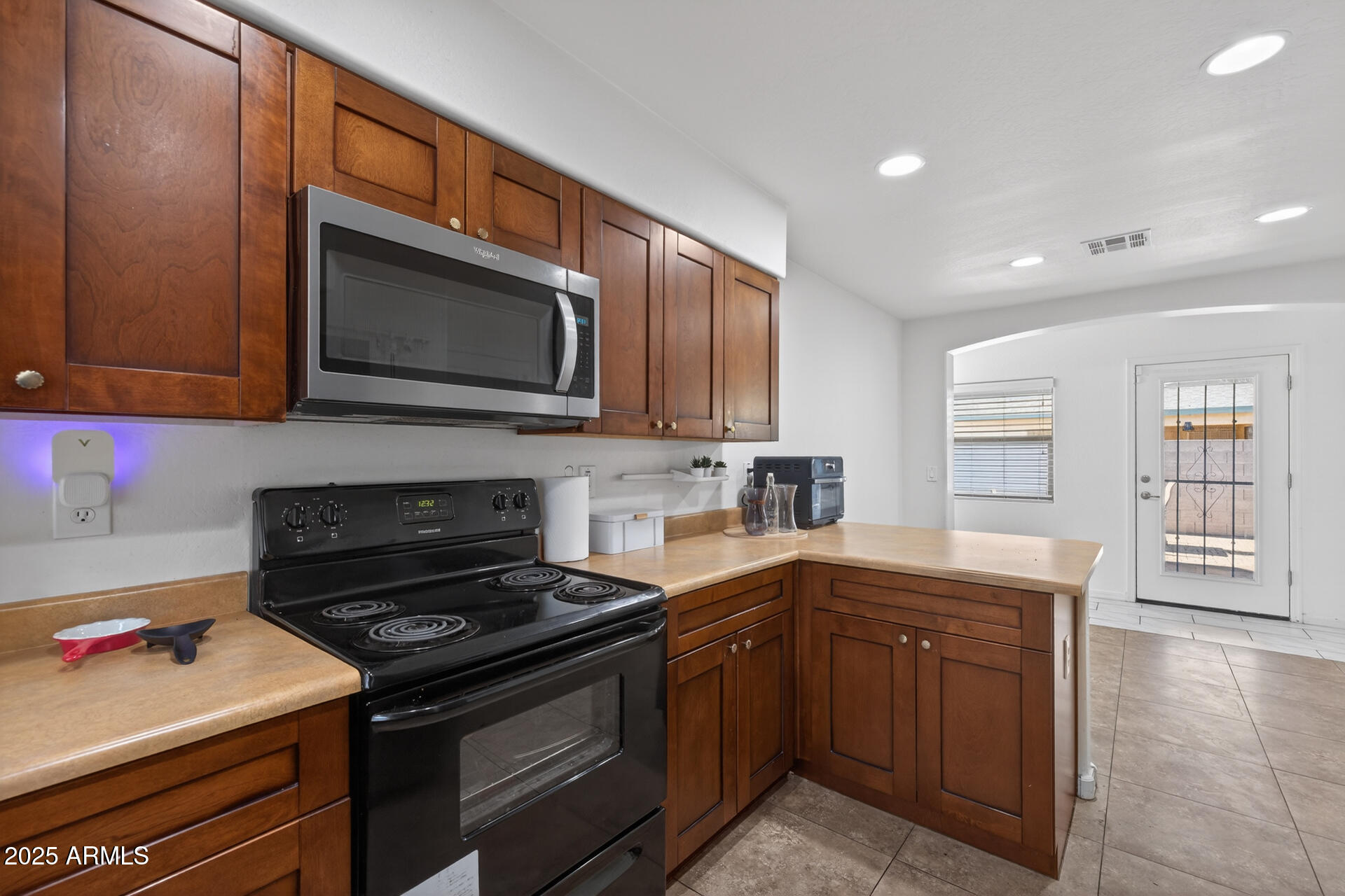 129 West Ian Drive Phoenix, AZ 85041 - Photo 7 of 21 a kitchen with stainless steel appliances granite countertop wooden cabinets stove top oven and sink