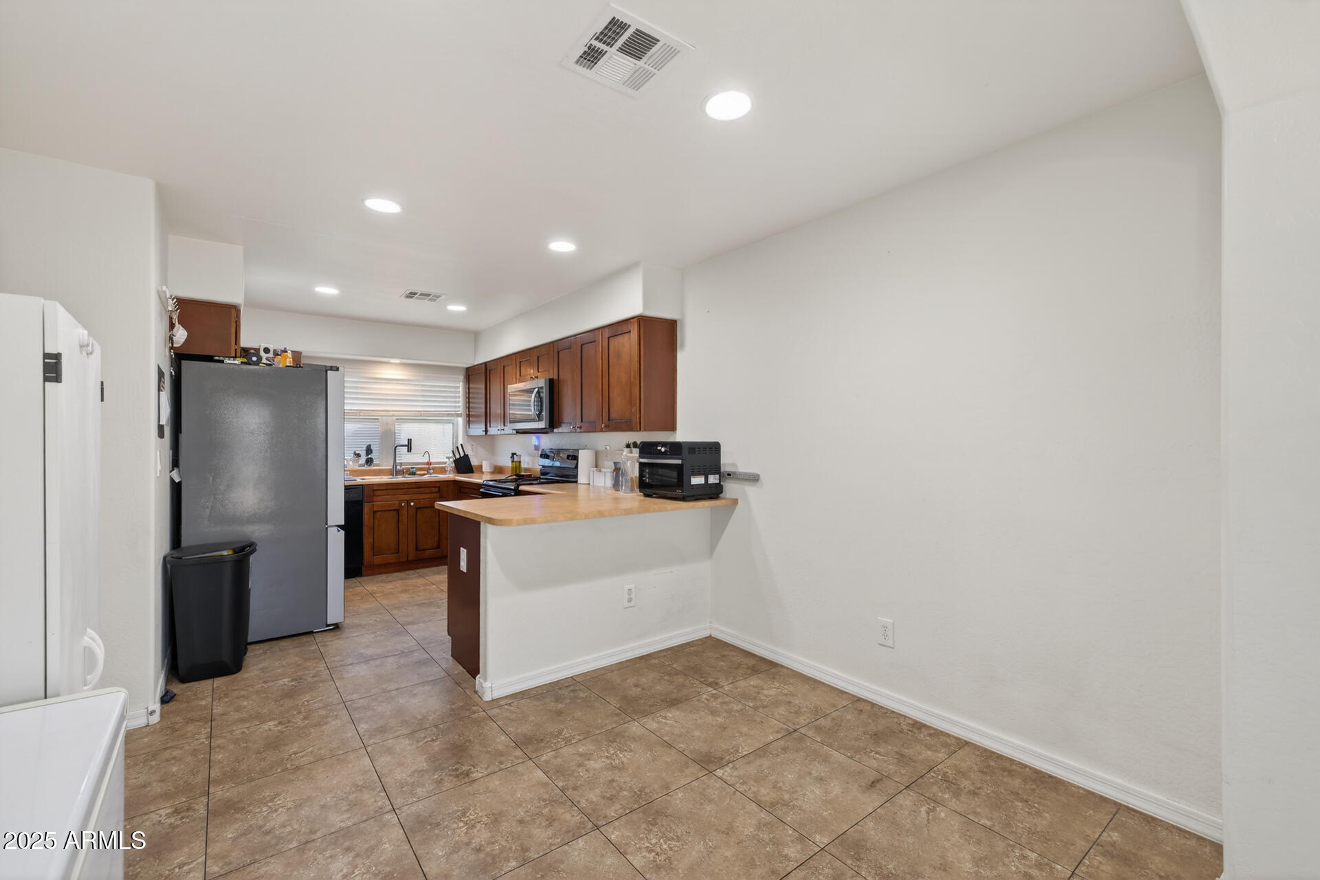 129 West Ian Drive Phoenix, AZ 85041 - Photo 8 of 21 a kitchen with refrigerator and microwave