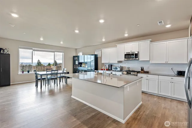 a kitchen with kitchen island a refrigerator sink and cabinets