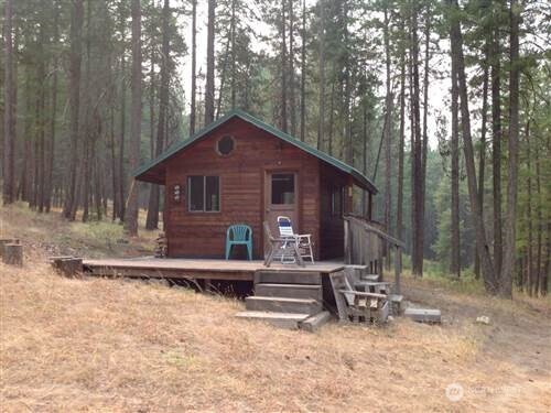 271 West Fork Road Conconully, WA 98819 - Photo 1 of 1 a front view of a house with yard and trees in the background