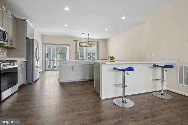 a kitchen with stainless steel appliances kitchen island a stove a refrigerator and cabinets