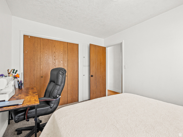 460 200 South Provo, UT 84606 - Photo 47 of 66 Bedroom featuring a closet, a desk, a textured ceiling, and carpet floors