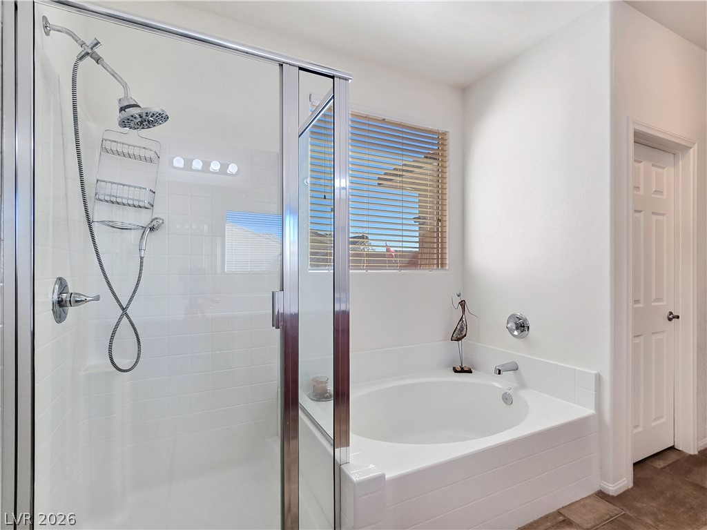 2485 Morrow Ridge Place Laughlin, NV 89029 - Photo 25 of 40 A well-appointed bath features a tiled shower and an adjacent built-in soaking tub, offering a tranquil retreat.