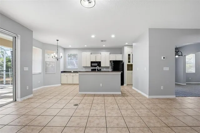a view of kitchen with refrigerator cabinets and window