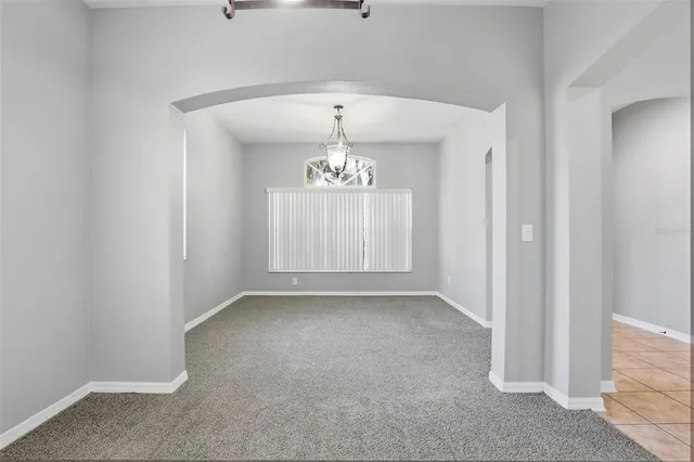 an empty room with windows and cabinet