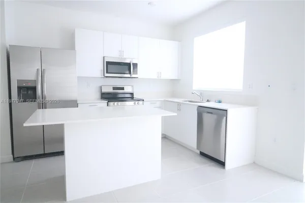 a kitchen with a sink appliances and cabinets