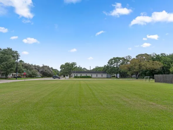 a view of a big yard with an outdoor space and trampoline