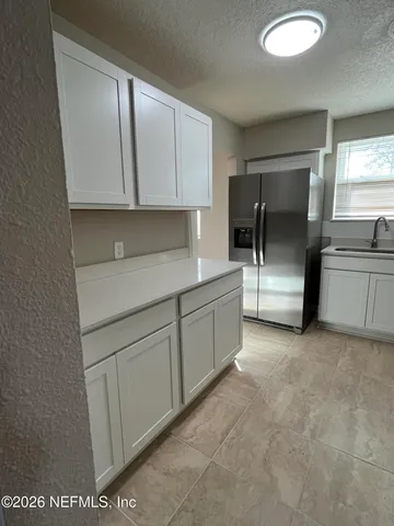 a kitchen with white cabinets and sink