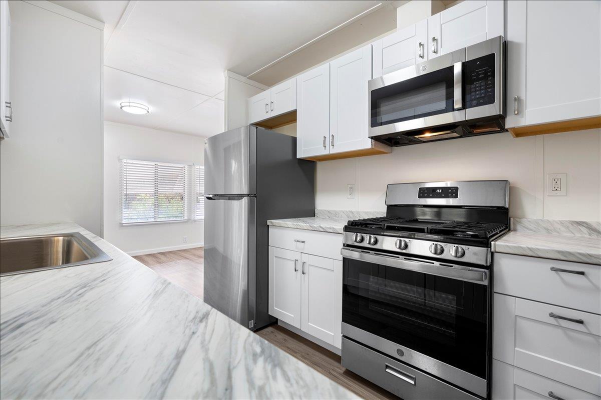 1525 Cold Springs Road, Unit 37 Placerville, CA 95667 - Photo 3 of 37 a kitchen with stainless steel appliances granite countertop white cabinets a stove a microwave and a refrigerator