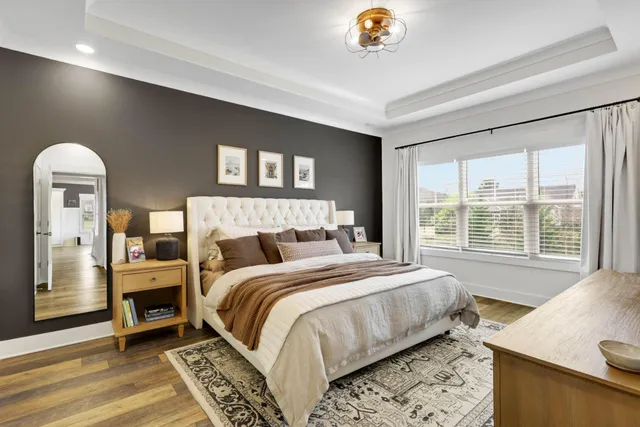 a bedroom with a bed and a dresser next to a window