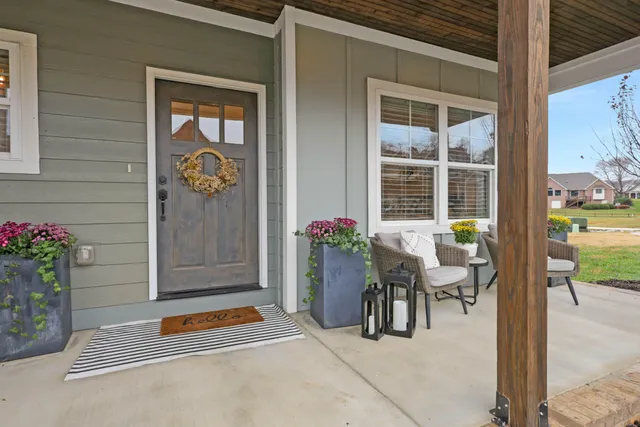 a balcony with table and chairs potted plants