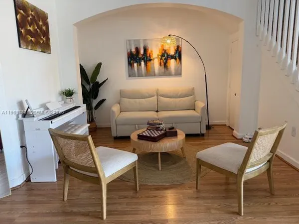 a living room with furniture and a painting on the wall