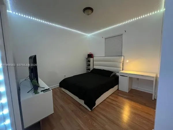 a bedroom with a bed and wooden floor