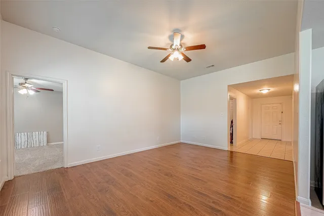 a view of empty room with wooden floor
