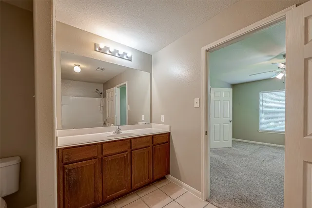 a spacious bathroom with a granite countertop sink and a mirror