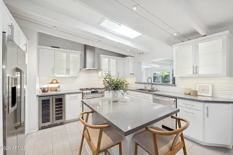 a kitchen with kitchen island a large counter top space appliances and cabinets