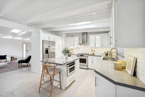 a kitchen with a sink a stove and chairs