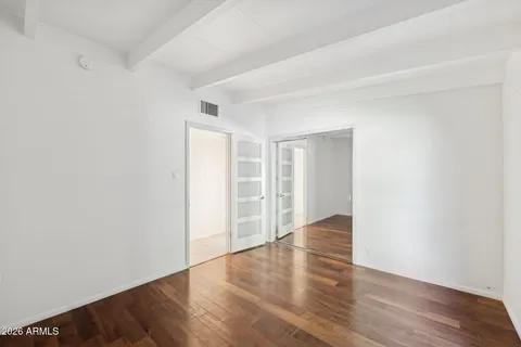 a view of patio with a table and chairs under an umbrella with a barbeque