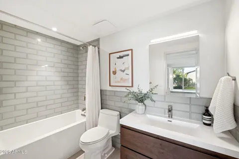 a view of a patio with a table and chairs under an umbrella with a small yard
