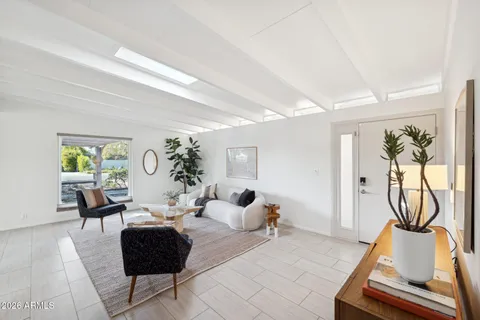 a living room with furniture flowerpot and wooden floor