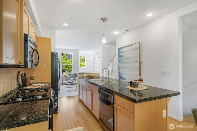 a kitchen with stainless steel appliances granite countertop a sink stove and cabinets