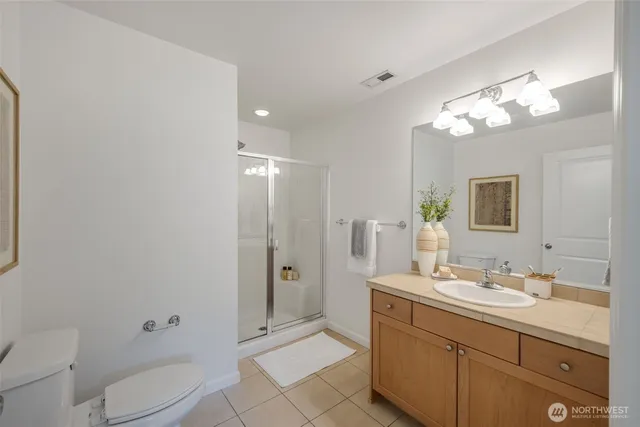 a spacious bathroom with a granite countertop sink a toilet and shower
