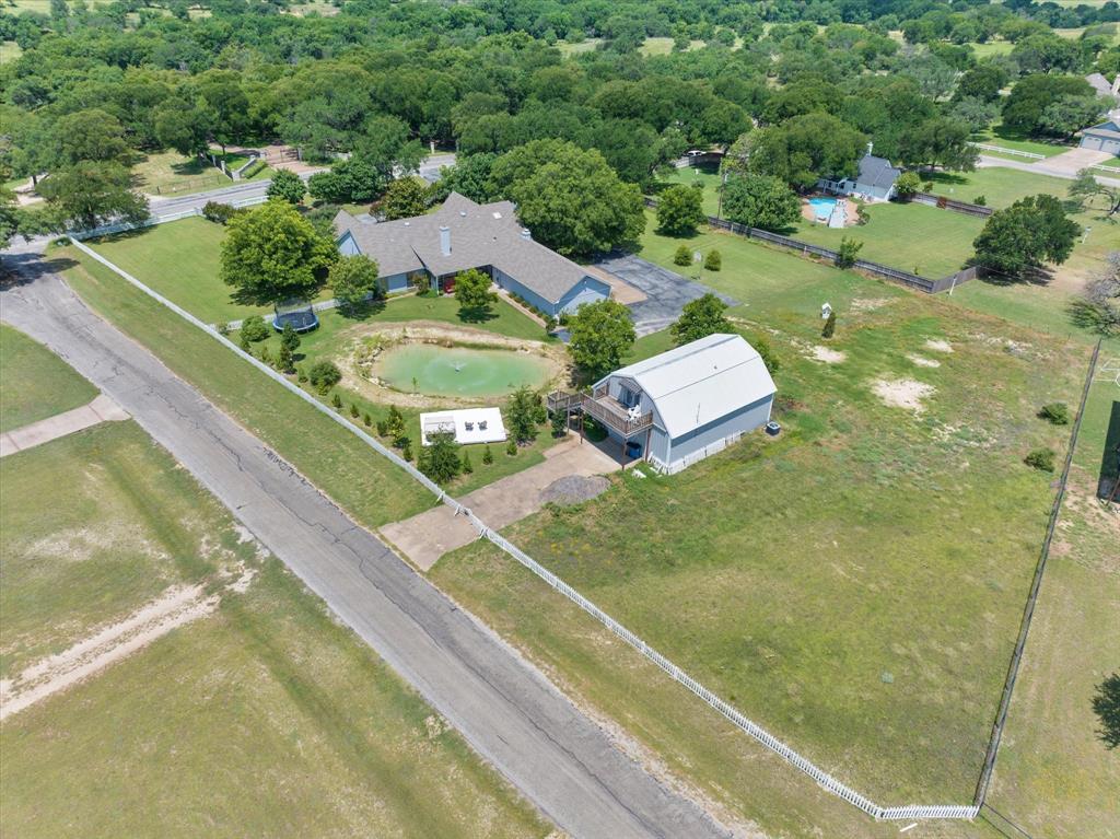 2717 Clear Lake Road Weatherford, TX 76087 - Photo 37 of 40 Expansive property featuring a main residence, secondary detached structure with a balcony, private pond, and perimeter fencing