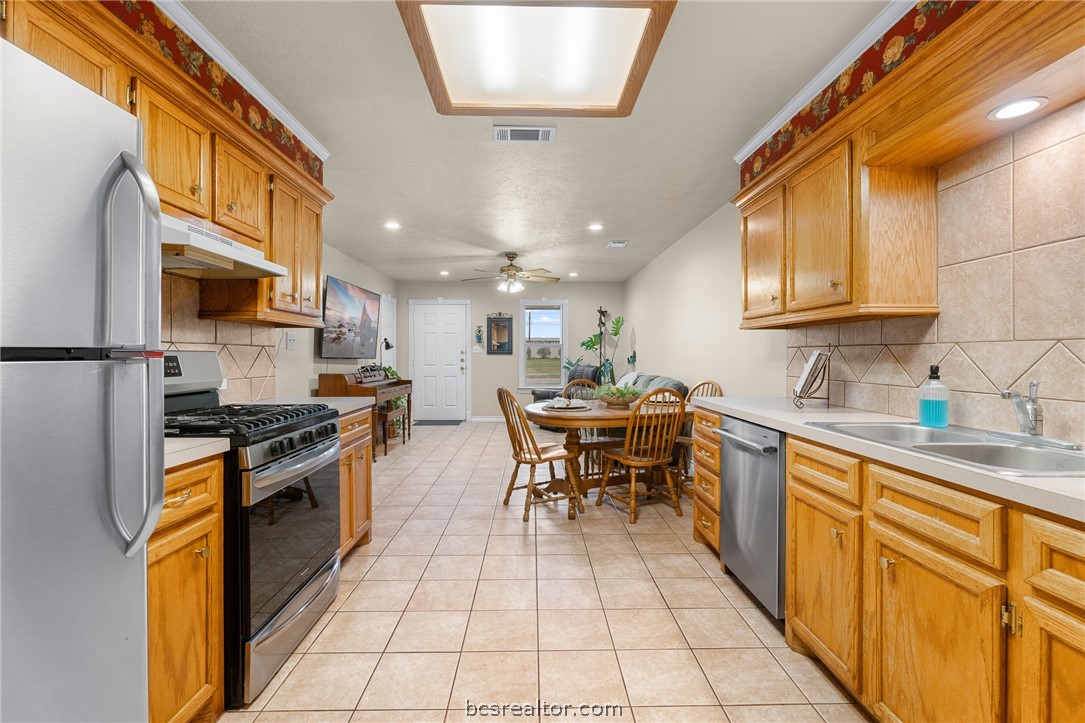 2287 North Earl Rudder Freeway Bryan, TX 77803 - Photo 32 of 32 a kitchen with stainless steel appliances granite countertop a sink a stove top oven a chimney and a center island