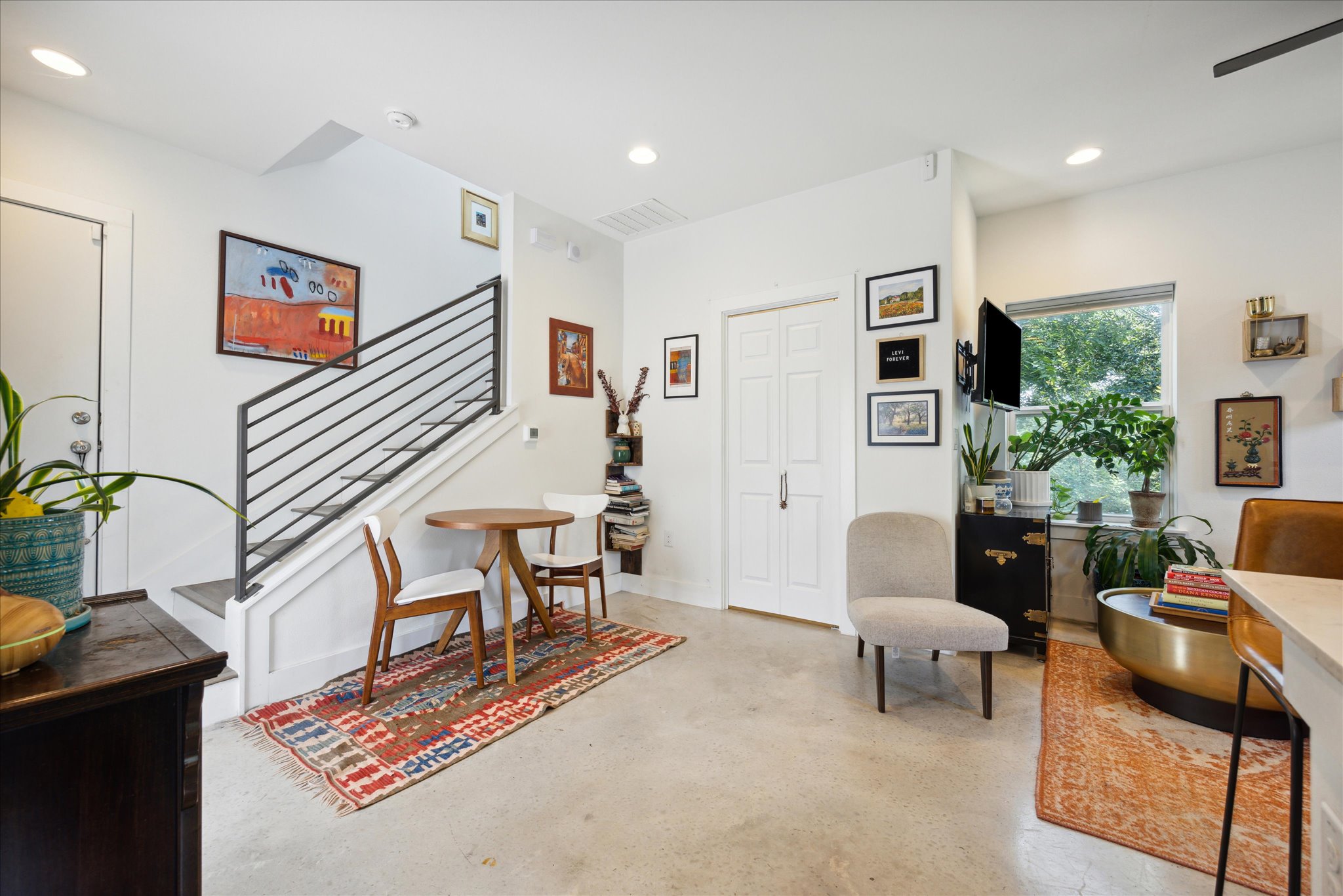5006 Baker Street, Unit B Austin, TX 78721 - Photo 2 of 16 a living room with furniture and paintings on the wall next to a window