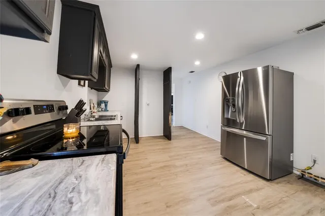 a kitchen with stainless steel appliances granite countertop a refrigerator and a stove top oven