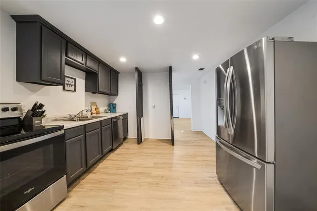 a kitchen with stainless steel appliances granite countertop a refrigerator and a sink