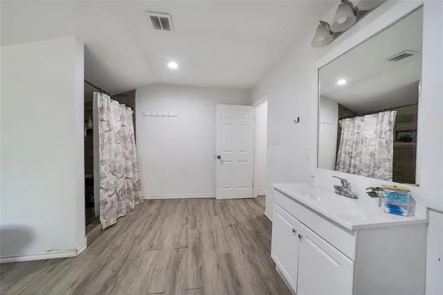 a bathroom with a sink a large mirror and shower