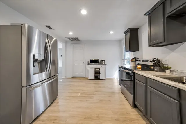 a kitchen with stainless steel appliances granite countertop a refrigerator and a sink