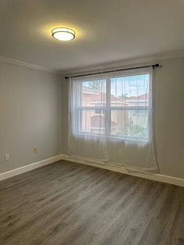 a view of a hallway with a chandelier fan and wooden floor