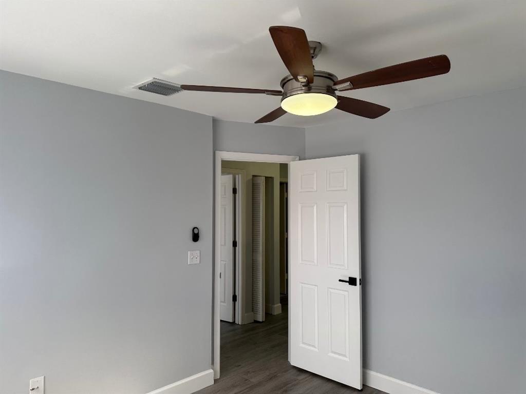 4151 Eastridge Circle Deerfield Beach, FL 33064 - Photo 36 of 53 a view of a hallway with a chandelier fan and wooden floor