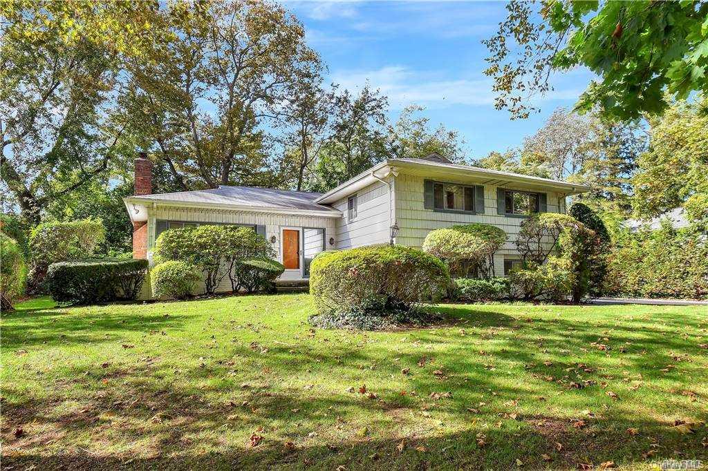 a view of a house with a big yard and potted plants
