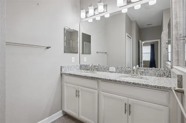 a bathroom with a granite countertop sink and a mirror