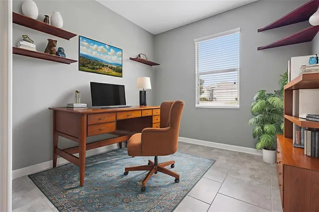 a view of a workspace with furniture and a window