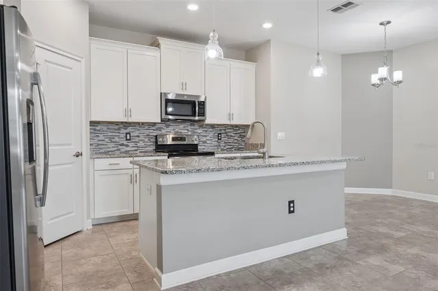 a kitchen with kitchen island granite countertop cabinets and refrigerator