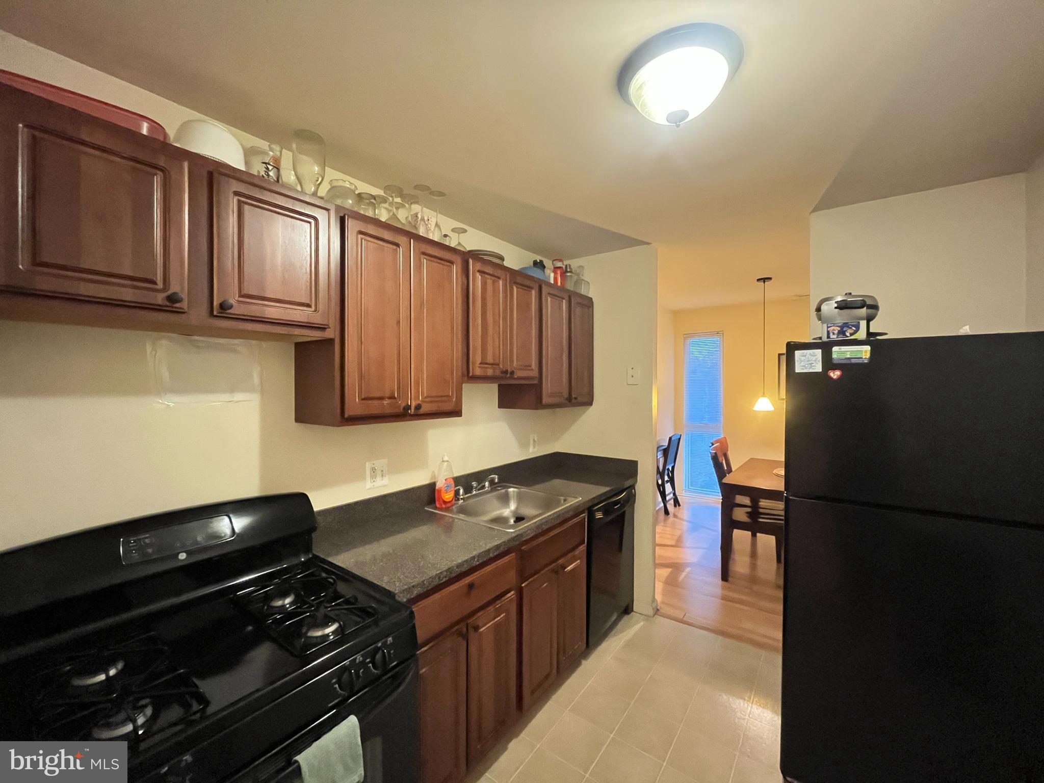 7101 Donnell Place, Unit D8 District Heights, MD 20747 - Photo 11 of 35 a kitchen with granite countertop stainless steel appliances and wooden cabinets