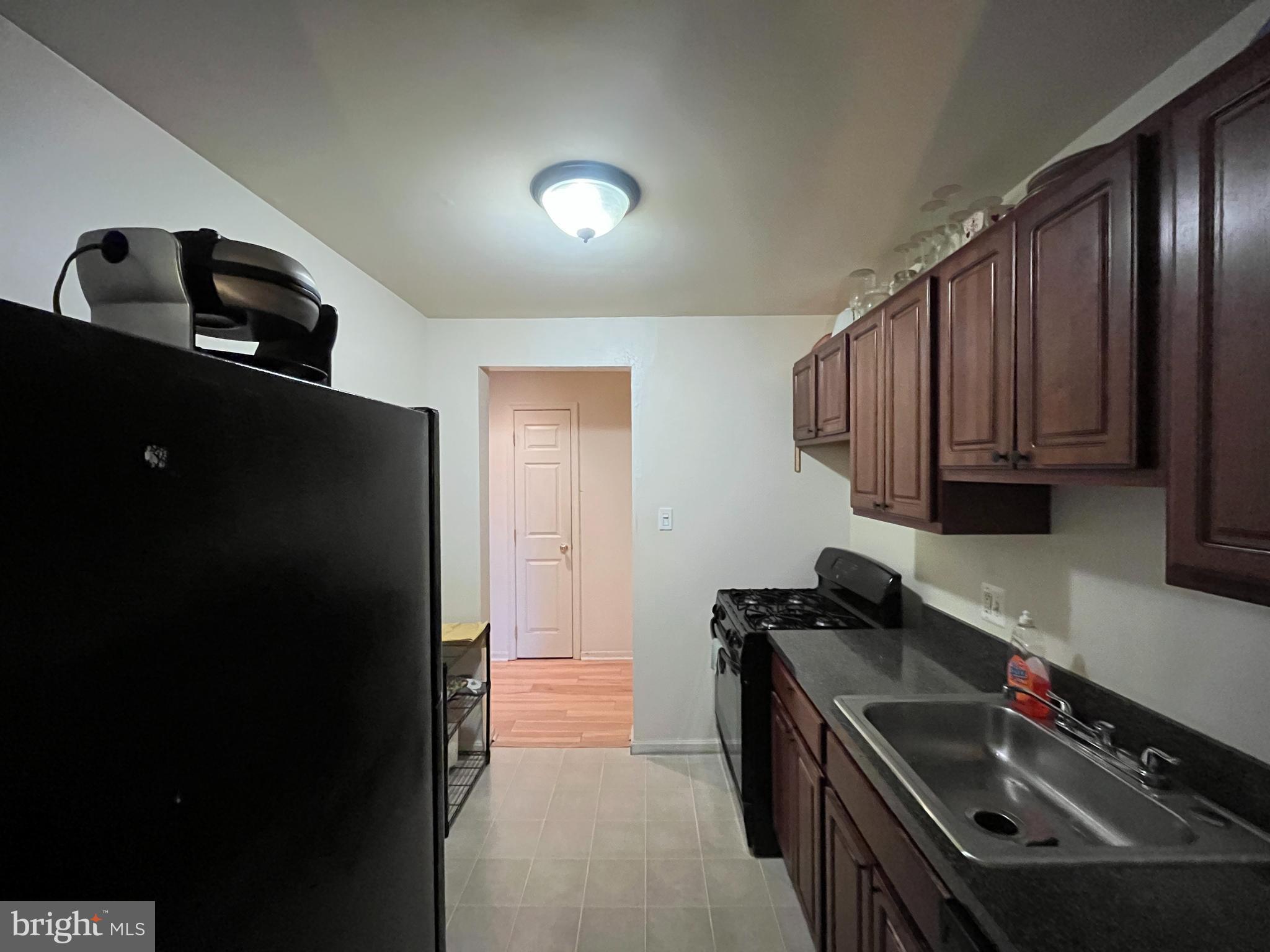 7101 Donnell Place, Unit D8 District Heights, MD 20747 - Photo 12 of 35 a kitchen with granite countertop stainless steel appliances a sink stove and refrigerator