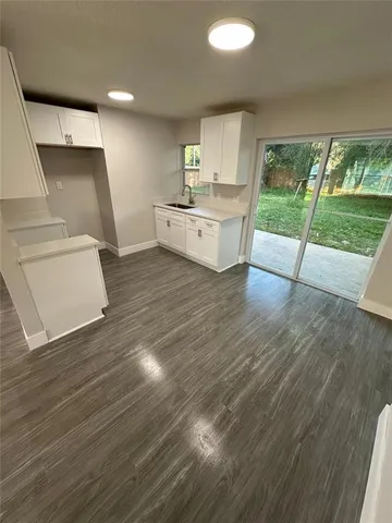 a kitchen with a sink and wooden floors