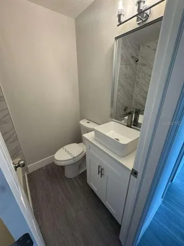 a bathroom with a sink a toilet a mirror and vanity