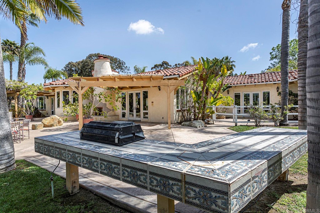 6944 Rancho Cielo Rancho Santa Fe, CA 92067 - Photo 23 of 37 a view of a patio with table and chairs with wooden floor and fence
