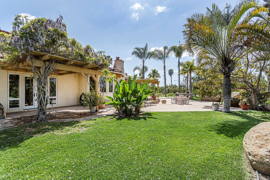 6944 Rancho Cielo Rancho Santa Fe, CA 92067 - Photo 24 of 37 a view of a house with a yard and a tree