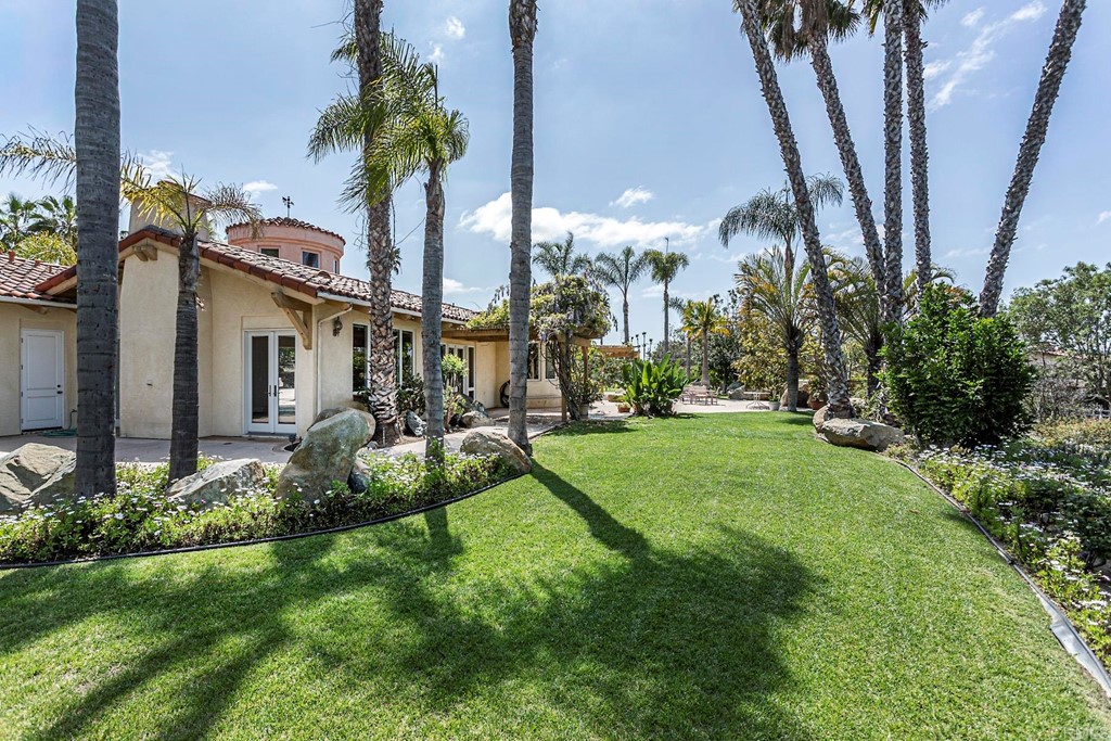 6944 Rancho Cielo Rancho Santa Fe, CA 92067 - Photo 29 of 37 a front view of a house with garden