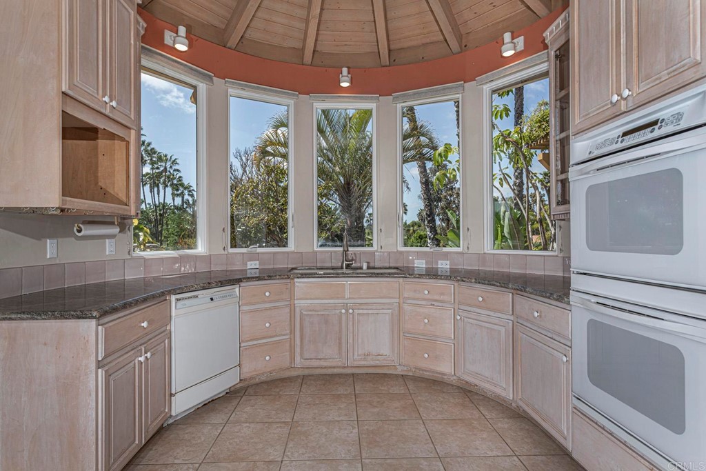 6944 Rancho Cielo Rancho Santa Fe, CA 92067 - Photo 7 of 37 a large white kitchen with a large window