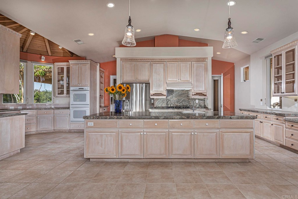 6944 Rancho Cielo Rancho Santa Fe, CA 92067 - Photo 8 of 37 a kitchen with granite countertop a sink and white cabinets